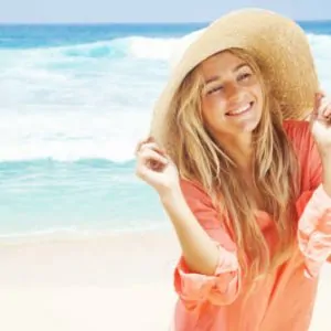 Women in hat on smiling on beach