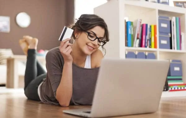 Woman holding card using laptop