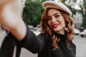 woman with beret smiling selfie